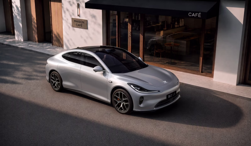 Silver 2026 IM L6 electric sedan outside a café, front three-quarter view
